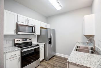 Neutral colored soft-close cabinetry and granite countertops